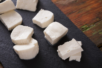 Homemade mozzarella on black stone background