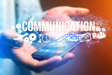 Concept of man holding a futuristic interface with communication title and multimedia icons flying all around - Internet concept