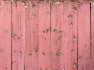 Verwitterte Wand aus Holzlatten mit rosafarbenem Anstrich