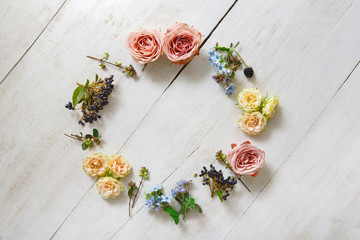 Flowers circle on white wood, top view