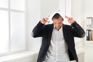 Exhausted businessman holding documents over head