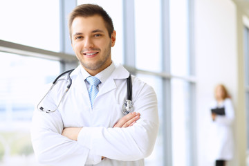 Smiling doctor waiting for his team while standing upright