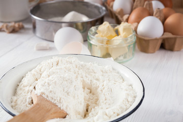 Baking ingredients on white rustic wood background, closeup