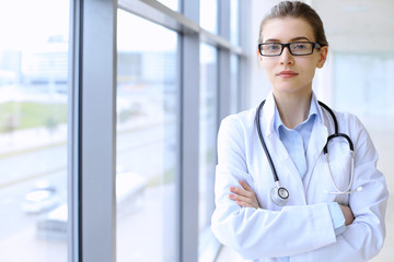 Medical doctor woman over clinic interiers background.