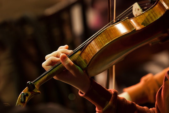 Fragment of a violin in the hands of a musician in a symphony orchestra