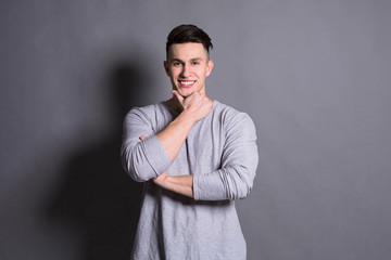 Young handsome man portrait at studio grey background