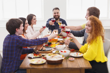People say cheers clink glasses at festive table dinner party