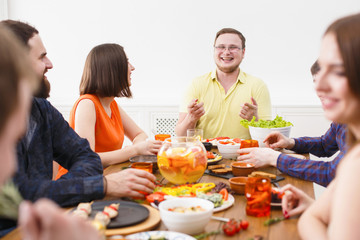 Group of happy people at festive table dinner party
