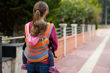 Fototapeta premium mother and child in a sling on the street