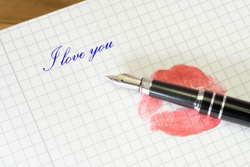 Ein Abdruck vom roten Lippen auf einem Brief und ein Text Ich liebe Dich