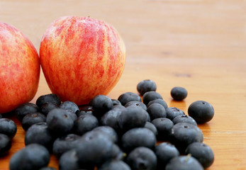 Apple and blueberries on a wooden table. Organic food recipes.