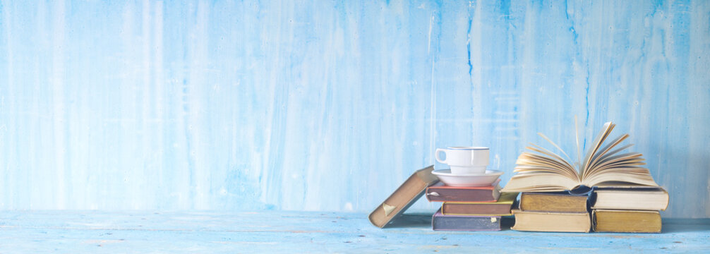 opened book, cup of coffee on blue grungy background, panoramic, copy space