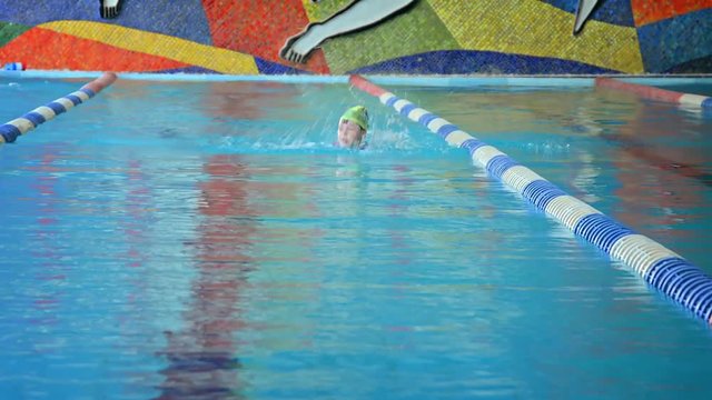 Little Girl Swims Laps in Indoor Public Pool. Video 1080p