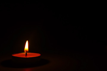 The light of burning candle in the dark