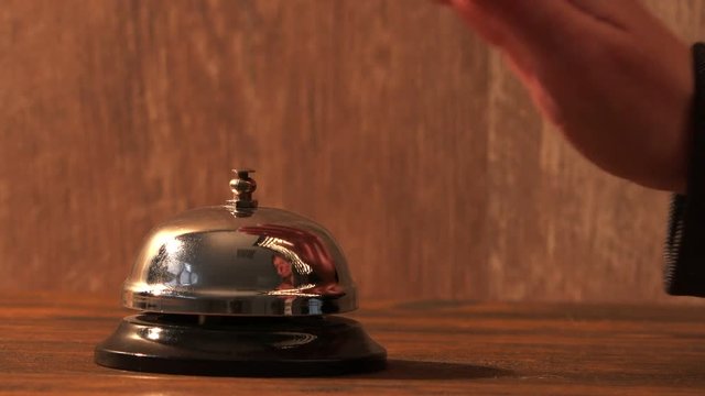 Nervous impatient businesswoman ringing hotel reception bell, warm retro toned footage