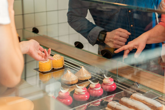 Woman choosing sweet pastry in confectionery