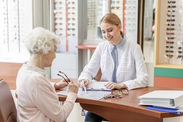 Fototapeta premium Attentive smiling young store assistant working