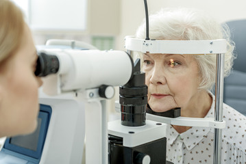 Young female ophthalmologist using apparatus