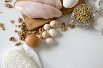 Healthy food full of proteins on white table. Chicken fillet eggs mushrooms, Lentils and peas and cottage cheese. Copy space for text. Sport diet background. Healthcare lifestyle or proteins concept.