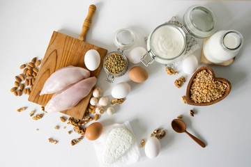 Food full of proteins on white table. Milk, sour cream, cheese, chicken fillet eggs mushrooms, Lentils and peas and cottage cheese. Proteins concept. Copy space for text. Sport diet healthy lifestyle.