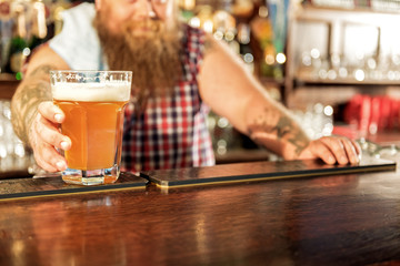 Fototapeta na wymiar Bartender handing out beer in pub