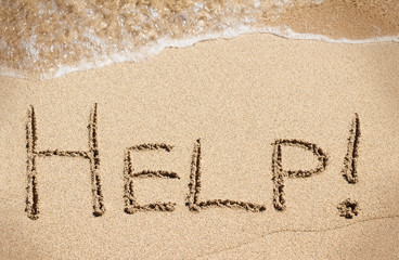 Help word written on sand beach