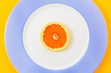 Top view of single grapefruit slice on plate centrally placed.