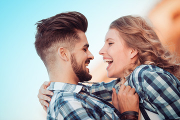 Young happy couple hugging on the city street