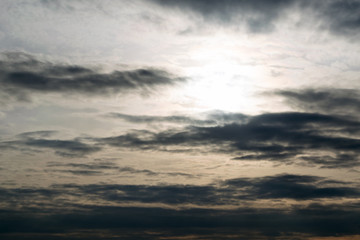 Fototapeta premium The dark sky, the evening sun, the clouds in a line along the horizon.