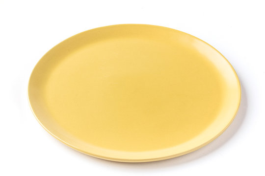 Close up of a round yellow plate on a  white background