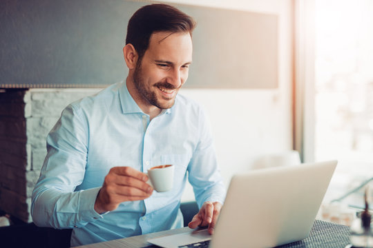 Young businessman using laptop in cafe