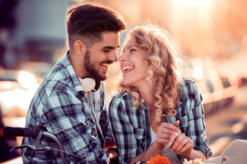 Happy young couple riding on a bicycle
