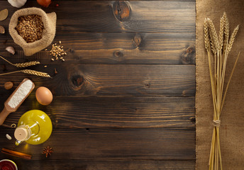 ears of wheat and bakery ingredients on wood