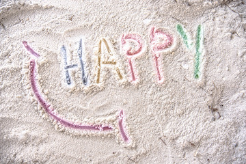 Fototapeta premium Word Happy smile written on sand beach