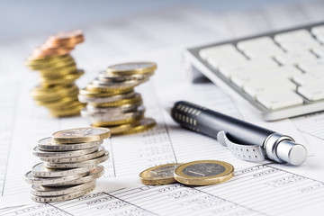 Finanzen, Euro Münzstapel, Kugelschreiber, Tabellen,  und Tastatur, Hintergrund