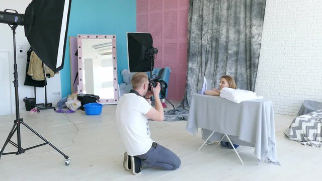  Photostudio backstage . Photographer explains poses to  woman model like housewife 
