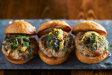 row of three turkey burger sliders on slate board