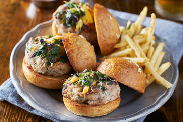 three turkey burger sliders with fries on plate