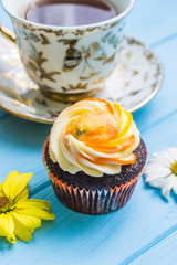 Still life with cup of tea and cake on the wooden background
