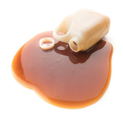 Oyster sauce poured from a bottle on a white background