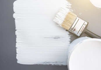 Paint brush with white paint stroke on grey background,top view