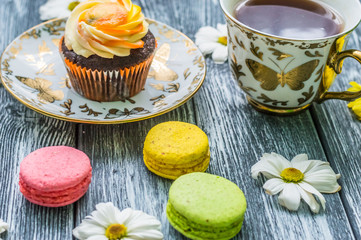 Still life with cup of tea and cake on the wooden background