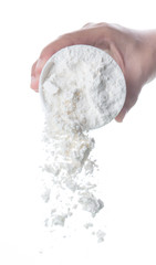 Pouring flour from the measure bowl on white background