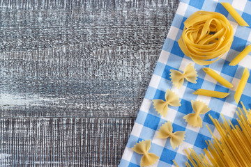 Mixed dried pasta on wood background texture