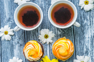 Still life with cup of tea and cake on the wooden background