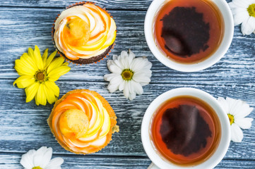 Still life with cup of tea and cake on the wooden background