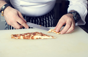 Chef of the restaurant prepares an omelette in a frying pan on the stove in the kitchen. Filtered foto.