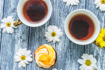 Still life with cup of tea and cake on the wooden background
