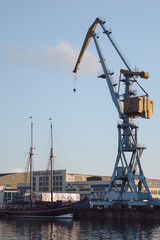 Fototapeta na wymiar cranes at harbor against sky