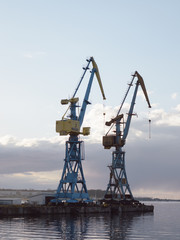 Fototapeta na wymiar cranes at harbor against sky